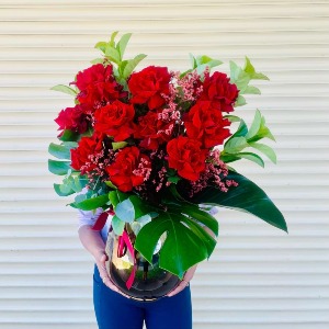 12 red reflexed roses in a vase